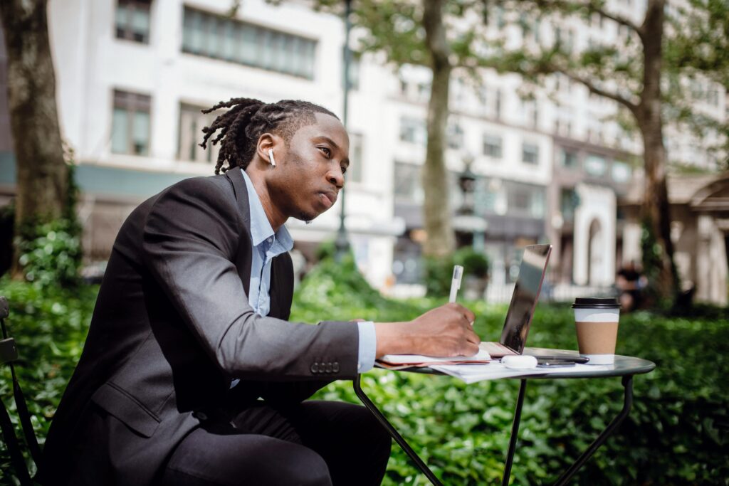 man with dreads in suit writing